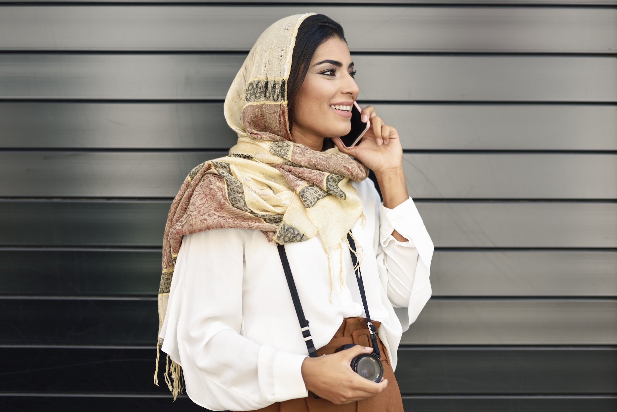 Spain, Granada, young Arab tourist woman wearing hijab, using smartphone